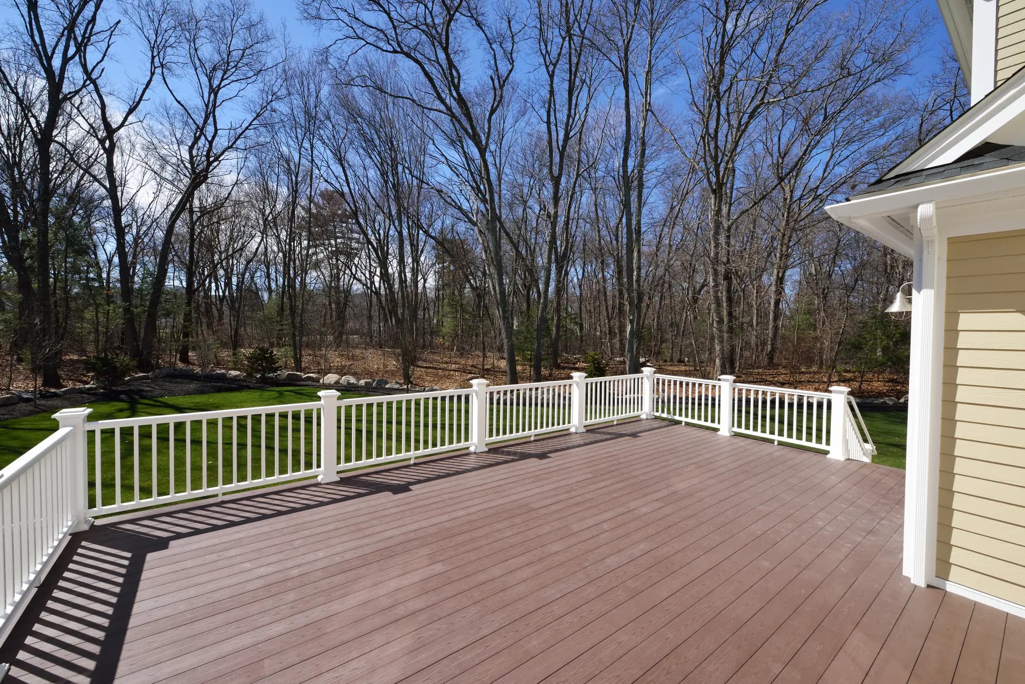 Finished deck with a railing looking out over a wooded yard