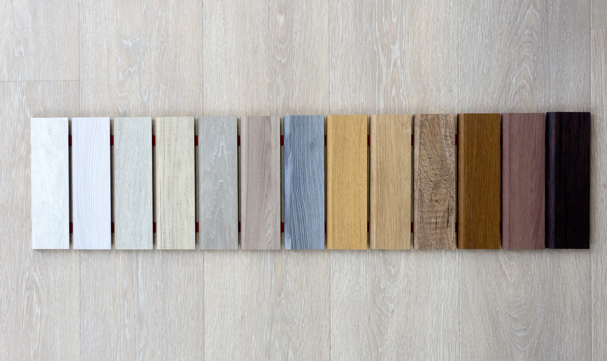 Row of flooring samples laid out light to dark