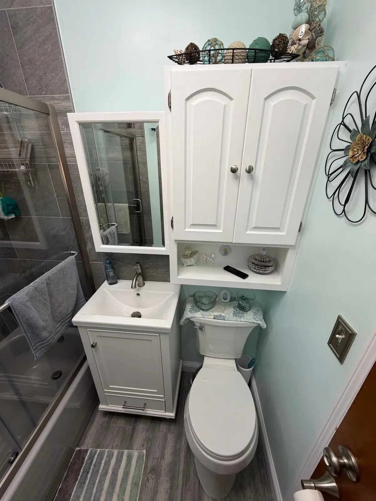 New vanity, mirrored cabinet and over-toilet storage in a finished bathroom