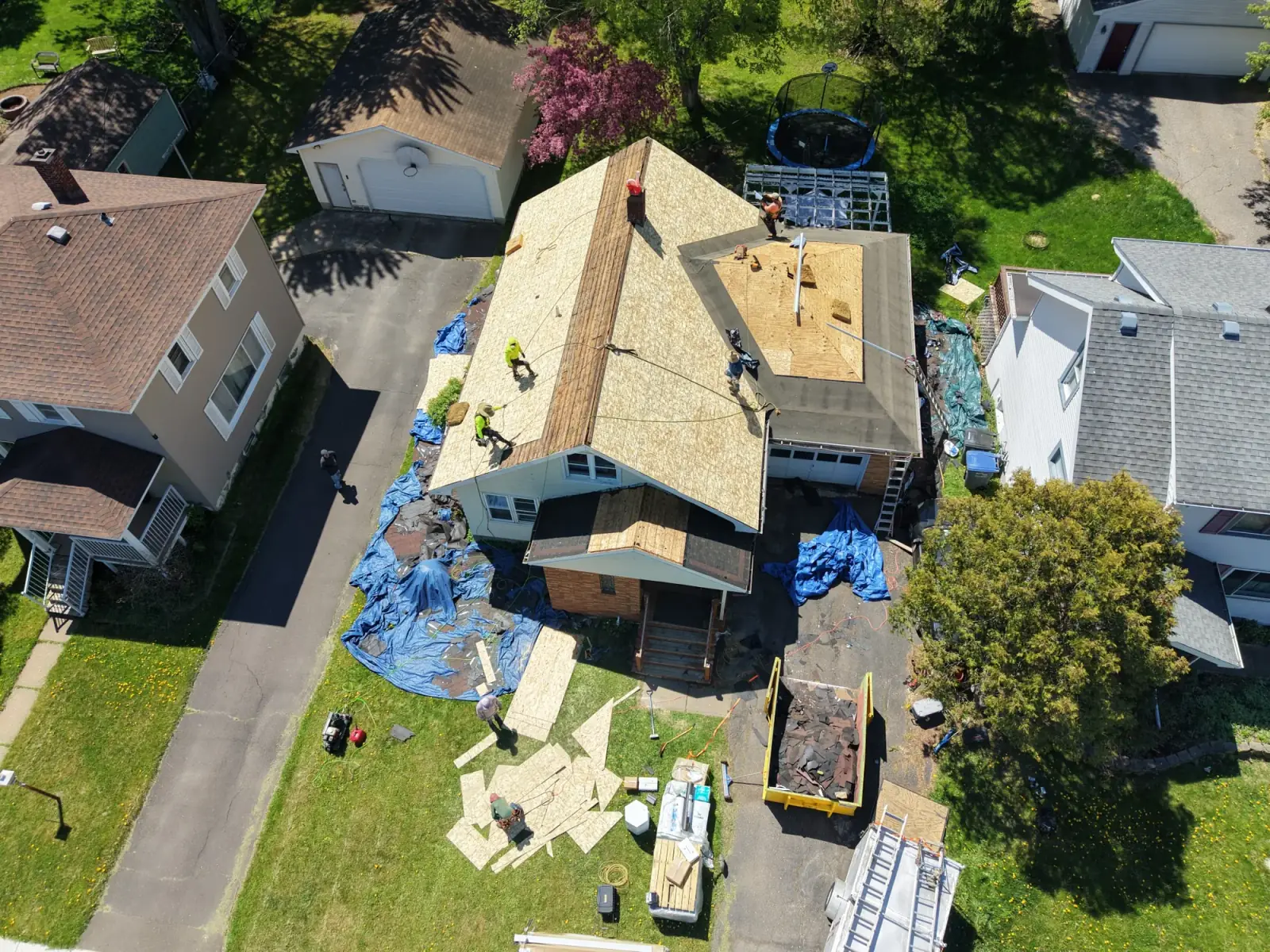 Roof stripped to the decking during a tear-off, with the crew working